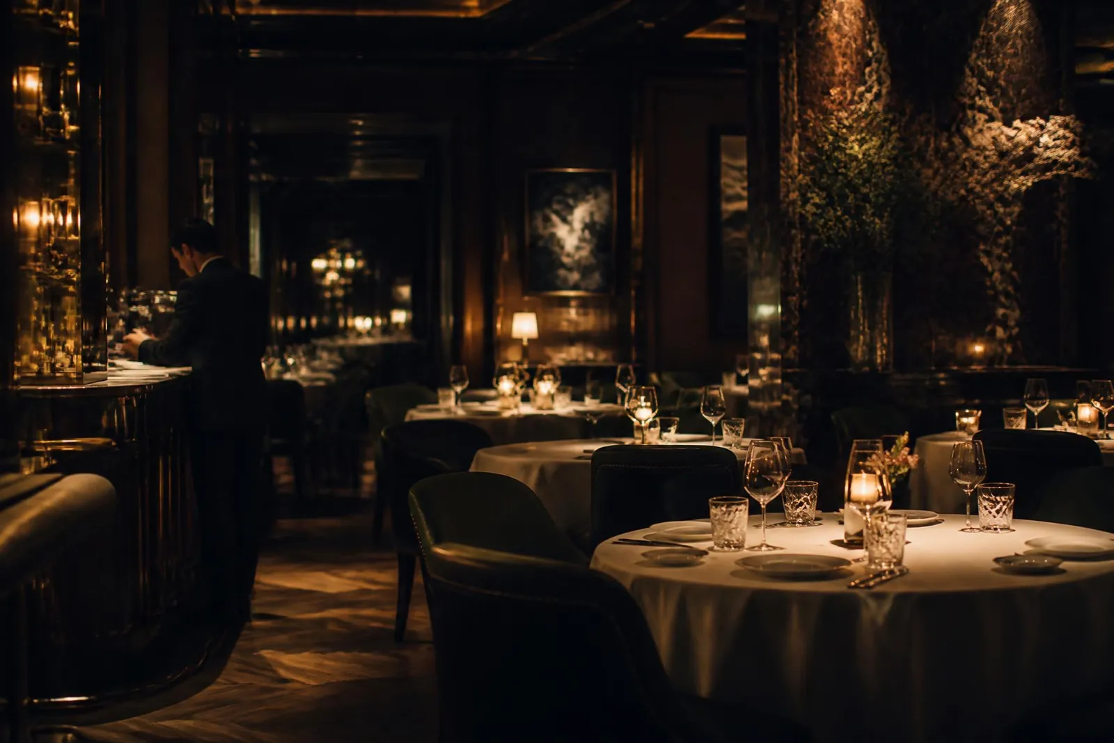 Comedor de restaurante de alta cocina iluminado con luz cálida, mesas montadas con cristalería